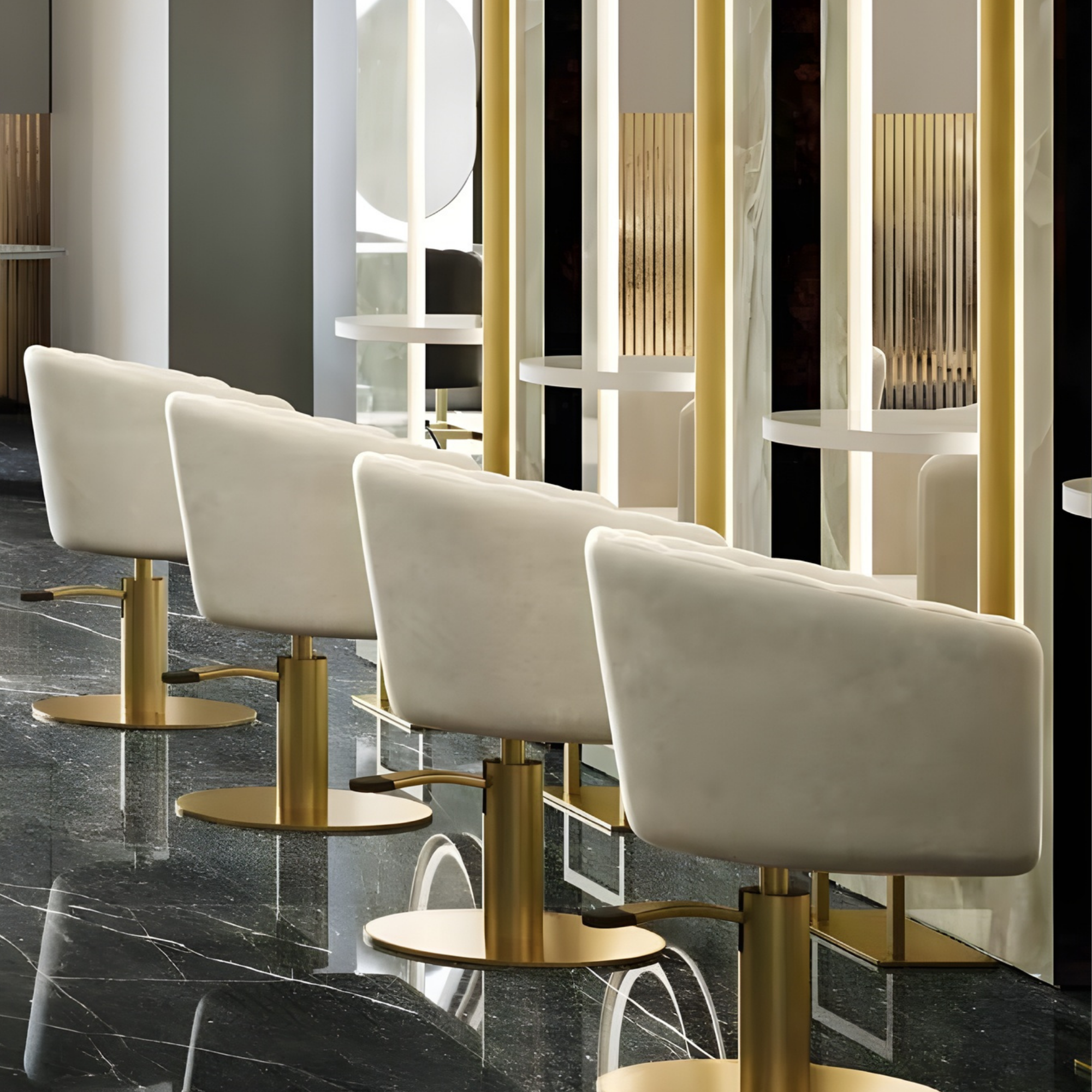 niz modernih bijelih frizerskih stolica s baršunastim presvlakama i zlatnim bazama ispred elegantnih ogledala u luksuznom salonu